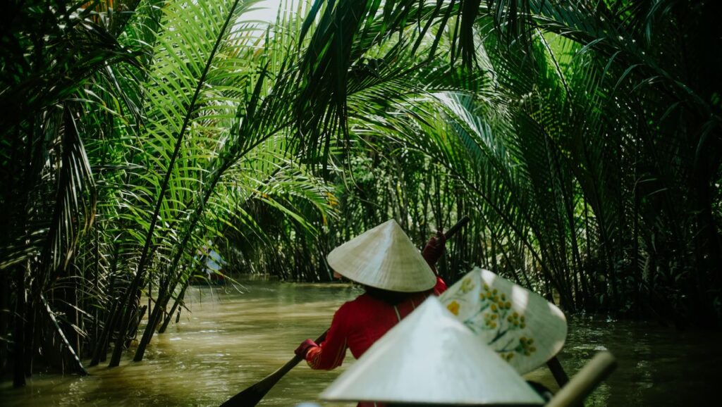 Experience a tranquil canoe journey through lush greenery in Tien Giang, Vietnam's serene waterways.