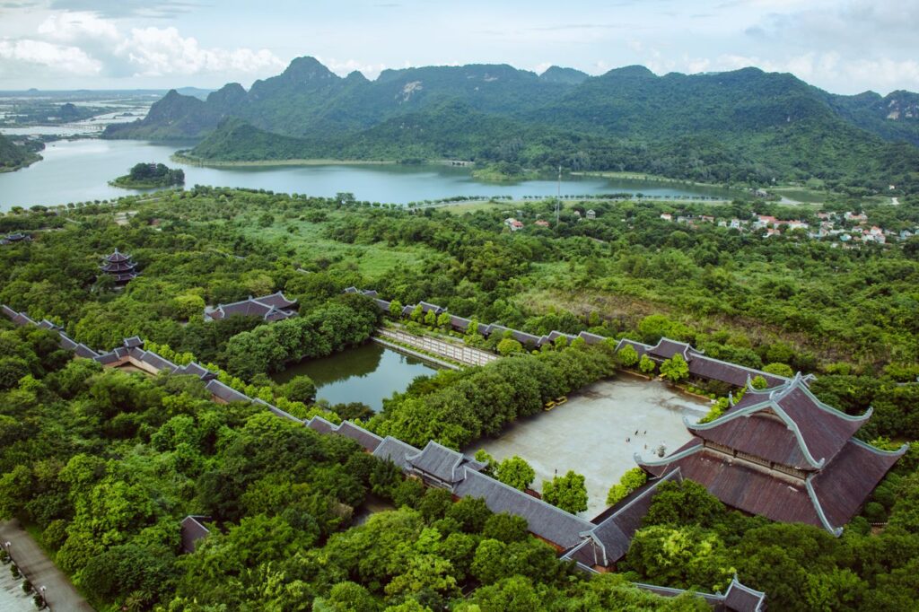 Scenic aerial shot of Bai Dinh Temple in Vietnam surrounded by lush greenery and mountains.